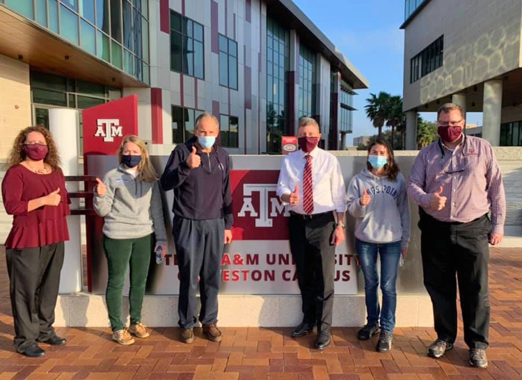 TAMMA administrators pose with those visiting from USMMA in front of campus. 